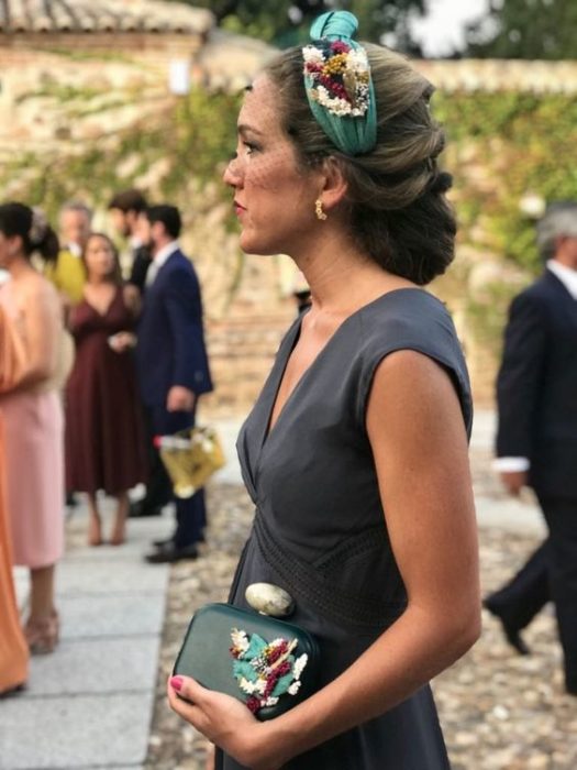 Invitada de boda con recogido elegante y diadema color verde con flores