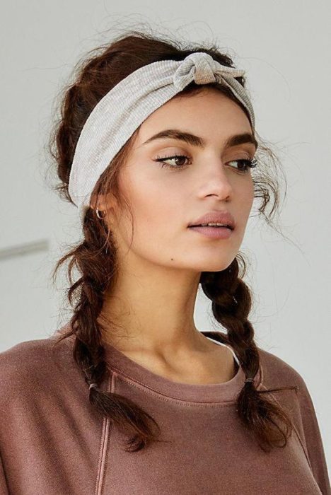 Chica morena de cabello rizado con trenzas y diadema gris