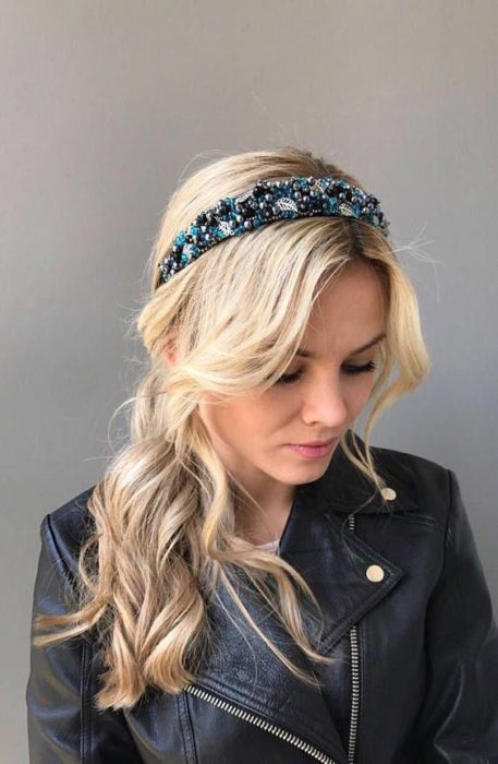 Chica rubia con coleta baja despeinada y diadema azul con piedras