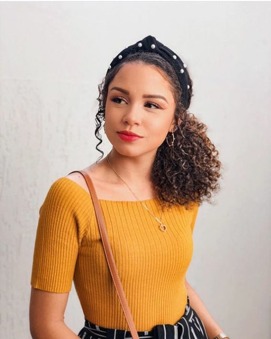 Chica de cabello rizado con una diadema negra