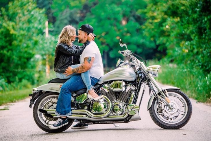 Pareja de novios durante una sesión de fotos mientras están en una motocicleta 