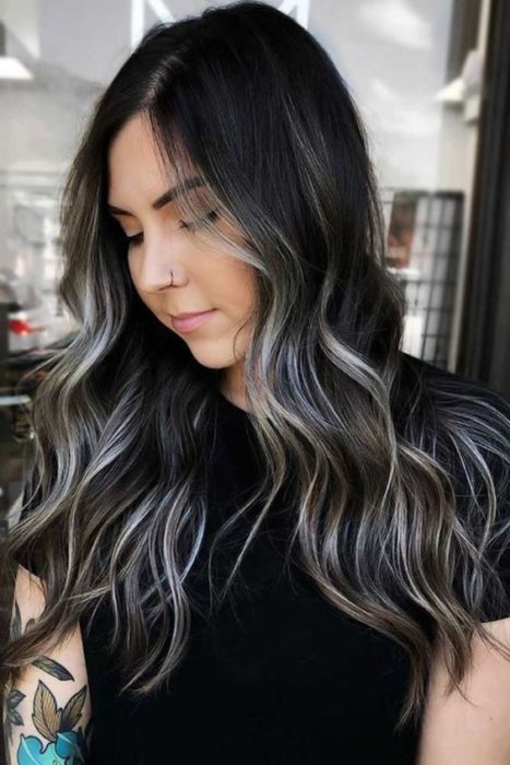 Chica con cabello largo y ondulado teñido al estilo silver highlights