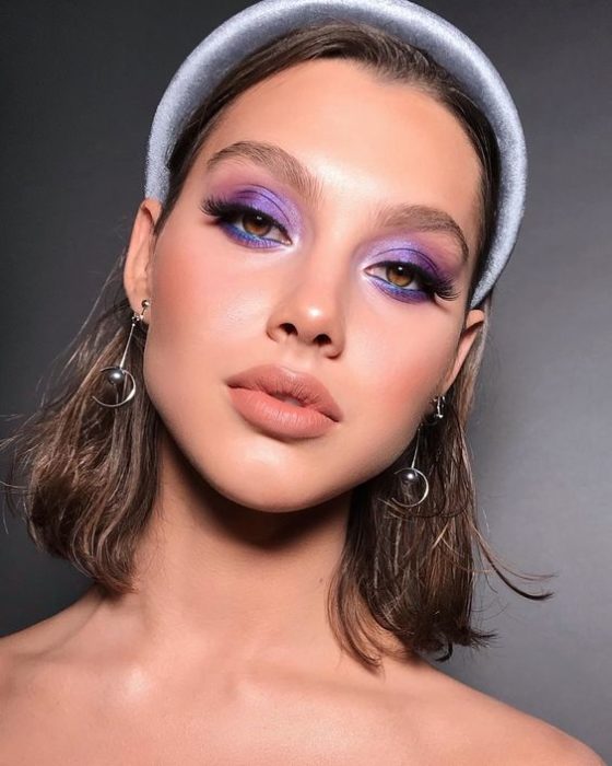 Modelo con sombras de ojos morada y diadema grande gris