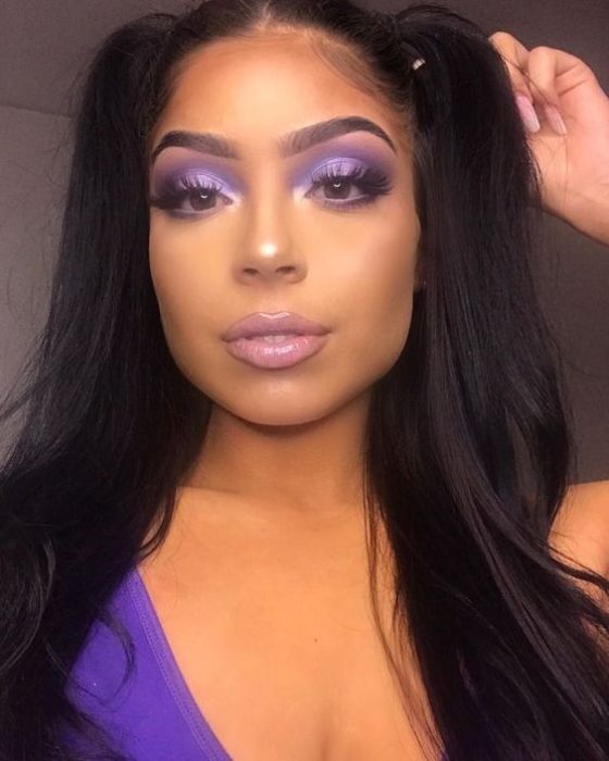 Chica morena de cabello largo con sombras de ojos moradas