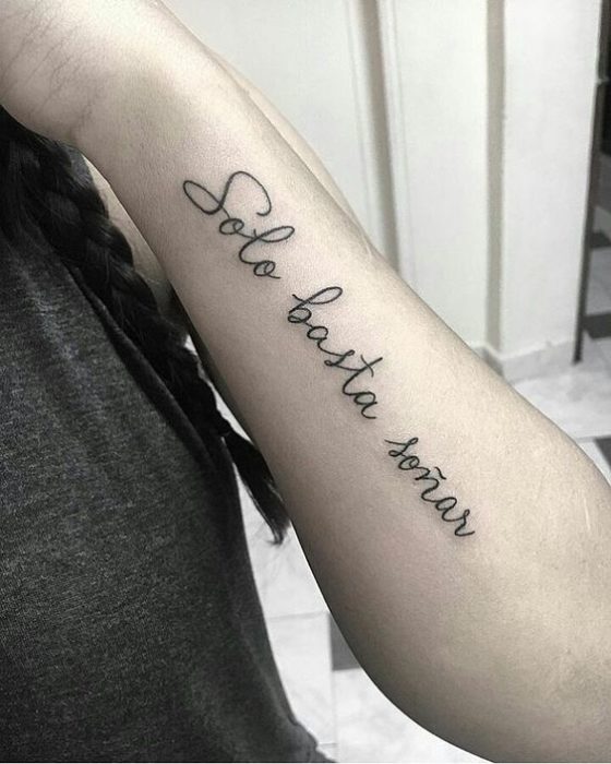 Tatuaje con frase inspiradora en el brazo