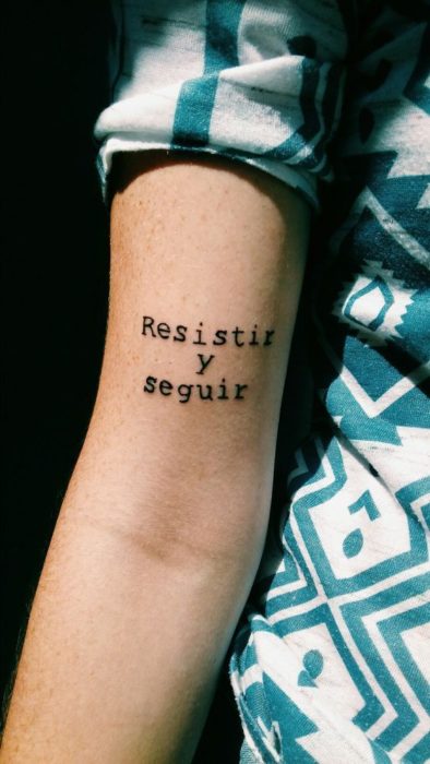 Tatuaje con frase inspiradora en el brazo