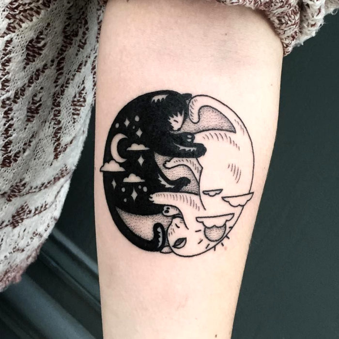 Tatuajes de gatos; tatuaje en el brazo de felinos blanco y negro durmiendo como el yin y yang