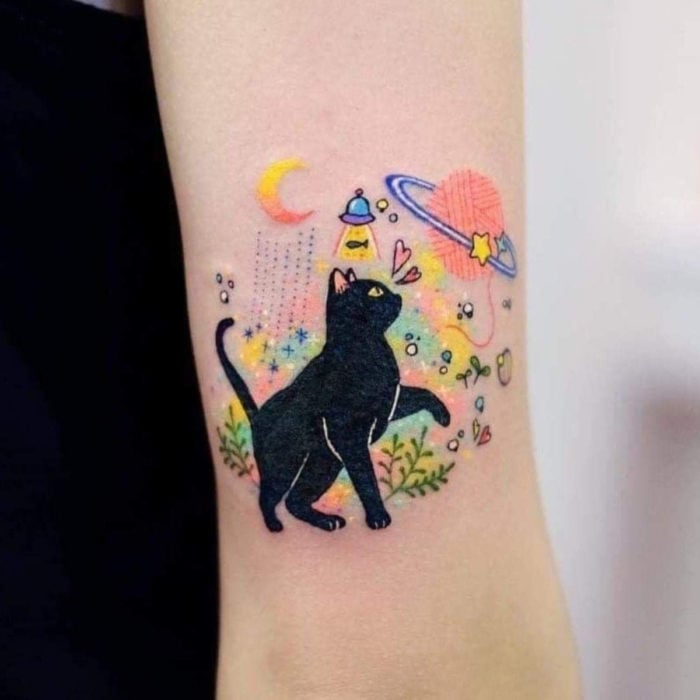 Tatuajes de gatos; tatuaje de felino negro en el espacio, ovnis, Saturno, bola de estambre