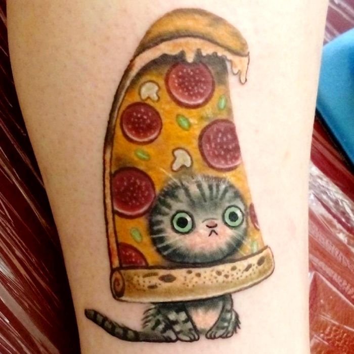 Tatuajes de gatos; tatuaje en la pierna de felino gris con rayas en una pizza de peperoni 