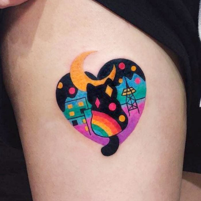 Tatuajes de gatos; tatuaje en la pierna de felino negro con arcoíris dentro de corazón con luna amarilla