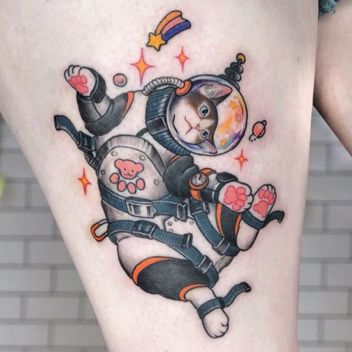 Tatuajes de gatos; tatuaje en el muslo de felino con traje de astronauta