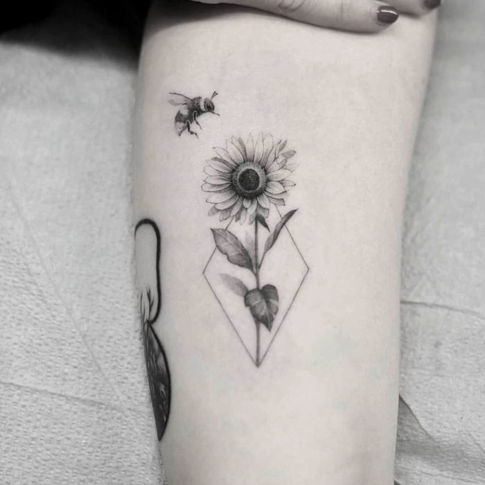 Tatuaje de girasoles con abeja en el brazo en blanco y negro