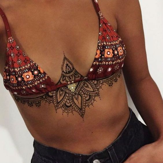 Tatuaje de mandala en pecho de una mujer 
