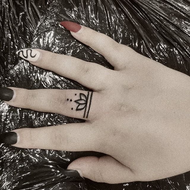 Chica con un tatuaje de una mandala que está en su dedo medio