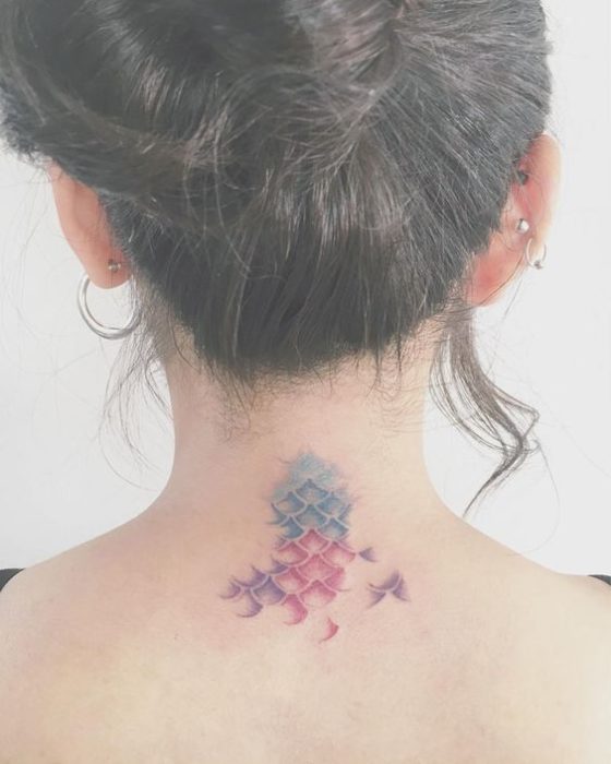 Tatuaje en forma de escamas de sinera en tonos verde, azul y morado