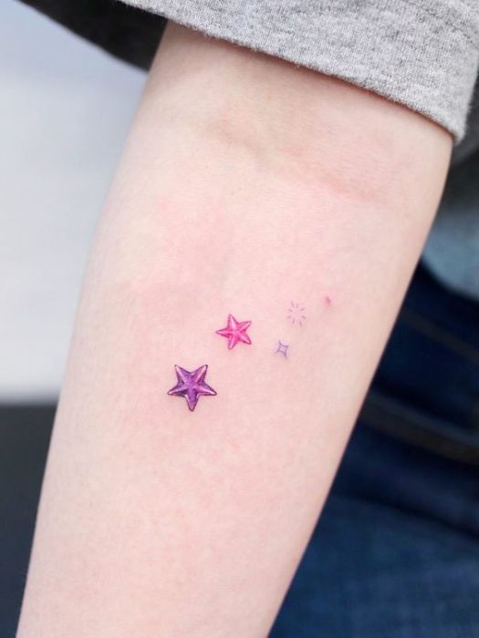 Minitatuaje de estrellas marinas en colores morado y fucsia 