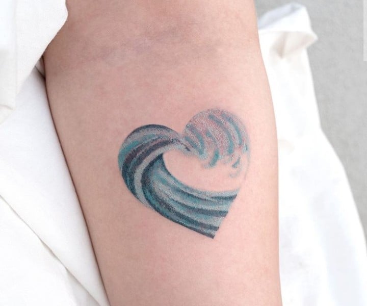 Tatuaje en forma de corazón con las del mar dentro en tono azul