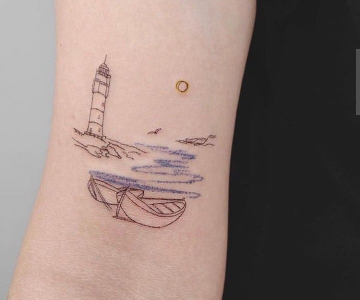Tatuaje de un bote viajando sobre las olas del mar acercándose a un faro en la playa