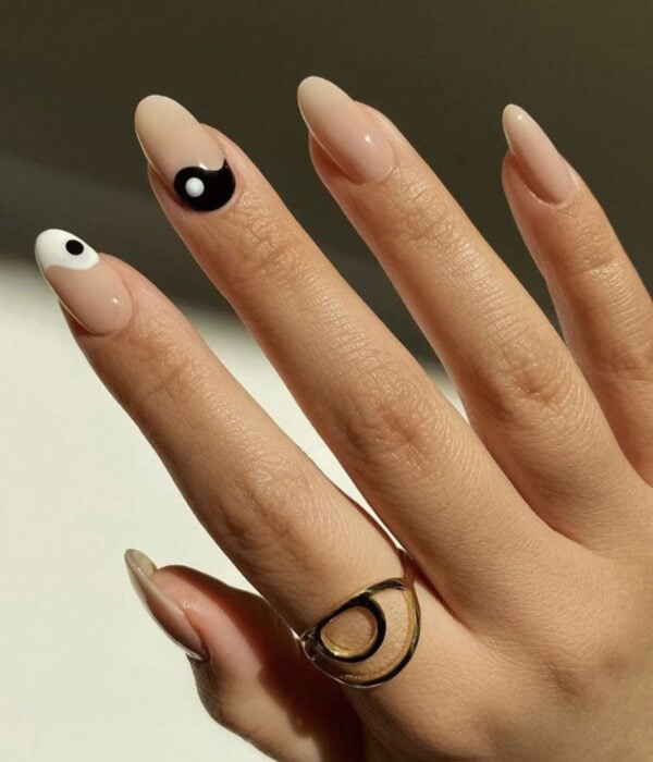 Diseño de manicure sencillos, femeninos y naturales; uñas largas en forma de almendra pintadas de color nude con yin y yang