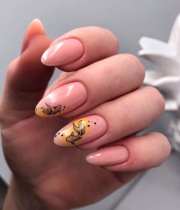 Diseño de manicure sencillos, femeninos y naturales; uñas largas en forma de almendra pintadas con esmalte nude y amarillo con dibujo de pez beta