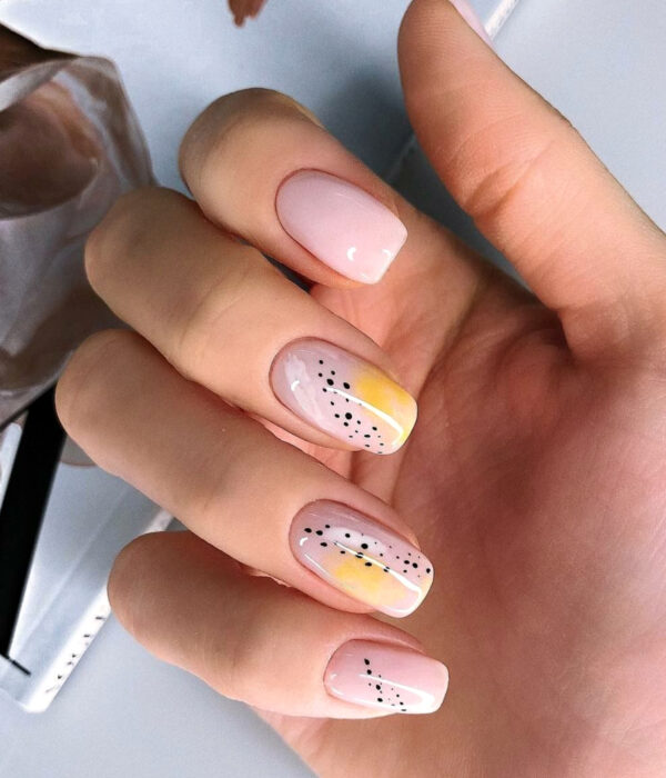 Diseño de manicure sencillos, femeninos y naturales; uñas largas cuadradas pintadas con esmalte nude y dibujos amarillos con puntos negros