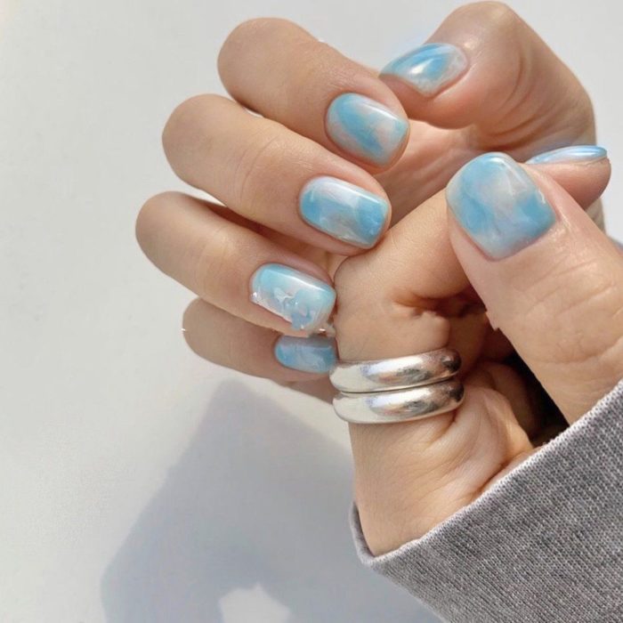 Manicura estilo tie dye en tono azul cielo