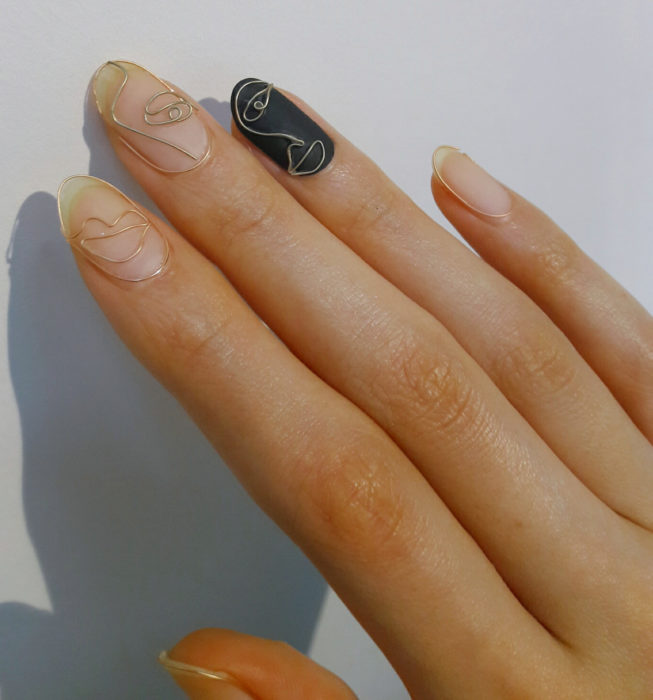 Uñas almendra estilo Picasso, manicure dorado con negro