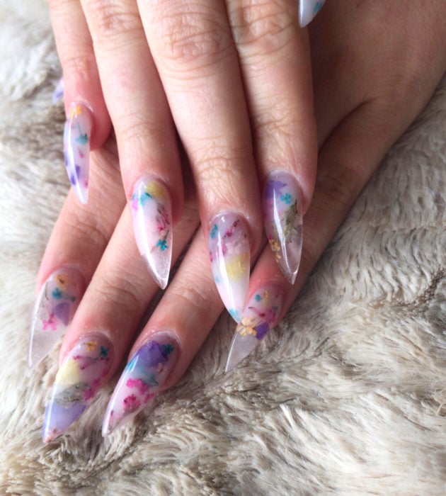 Diseños de manicura milk bath; uñas largas stiletto color lilas con flores rosas, amarillas y azules