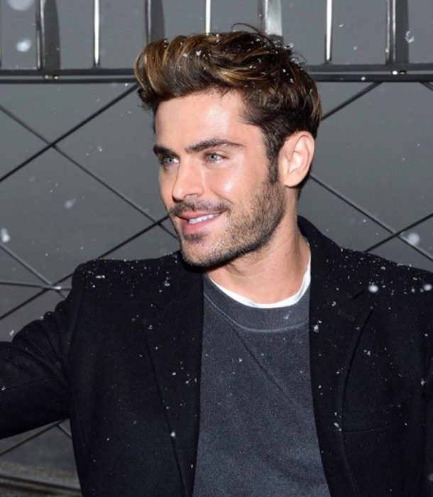 Zac Efron posando para fotografía y sonriendo