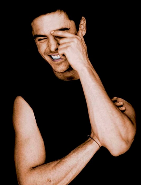 Zac Efron sonriéndo y tapándose la mitad del rostro con una mano
