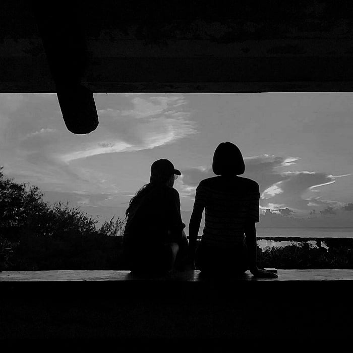 imagen de pareja sentada frente a una ventana