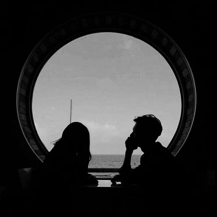 imagen de una pareja frente a una ventana, sentados en una mesa