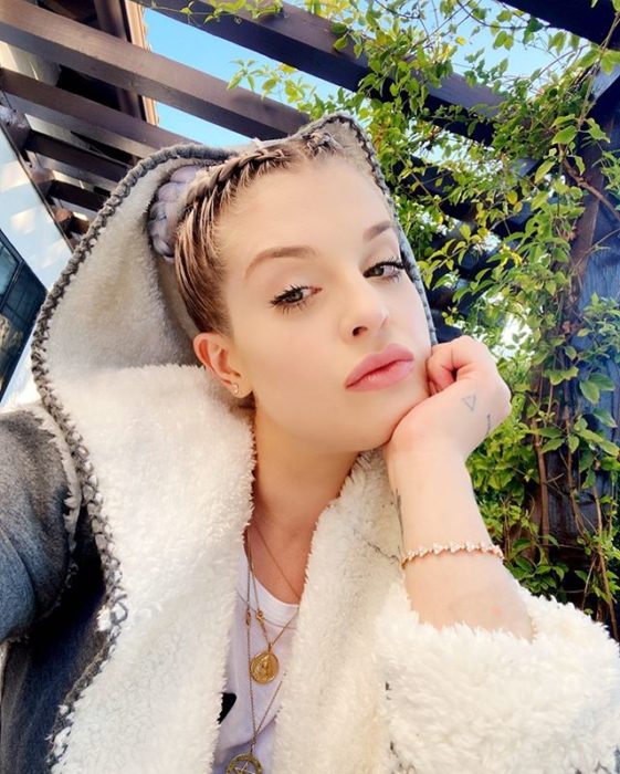 Kelly Osburne peinada con trenzas holandesas, usando una sudadera con maquillaje tenue