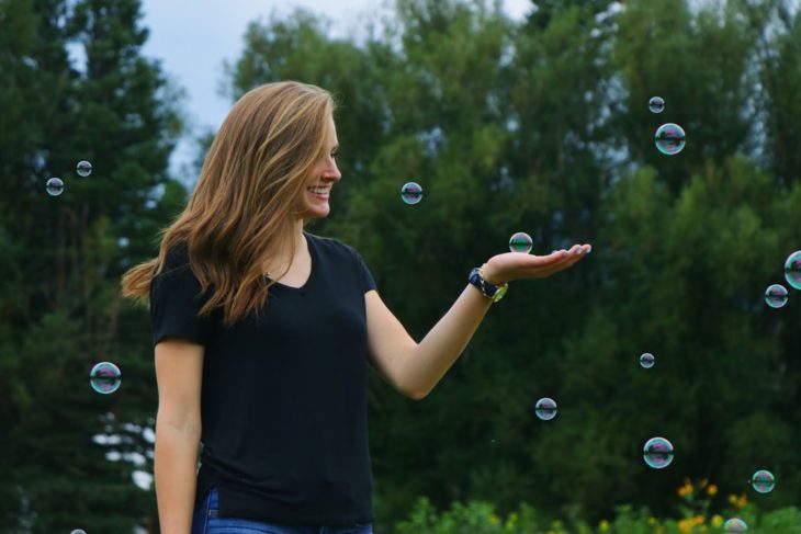 Chica sonriendo tocando las burbujas