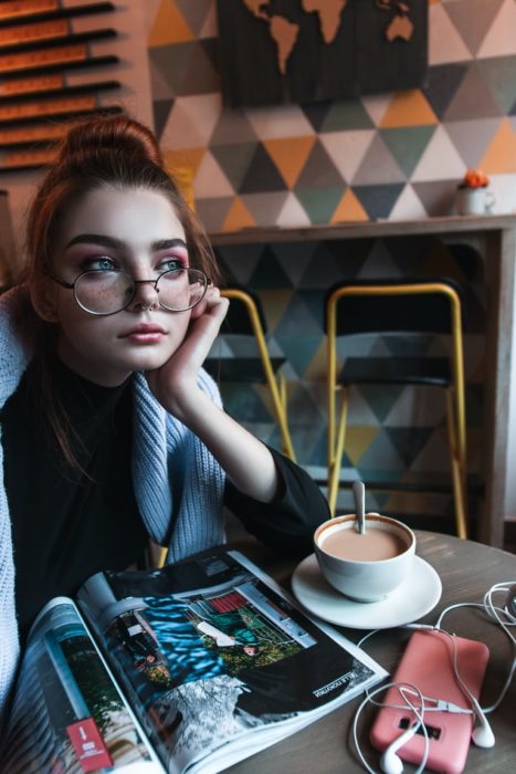 Chica sentada, tomando un café