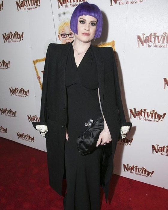 kelly osburne con el cbaello lila, y usnado outfit negro, en una alfombra roja