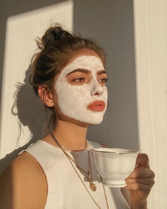 Chica tomando té mientras su mascarila actua