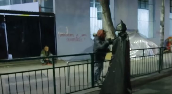 Batman solidario entregando comida a personas en situación de calle