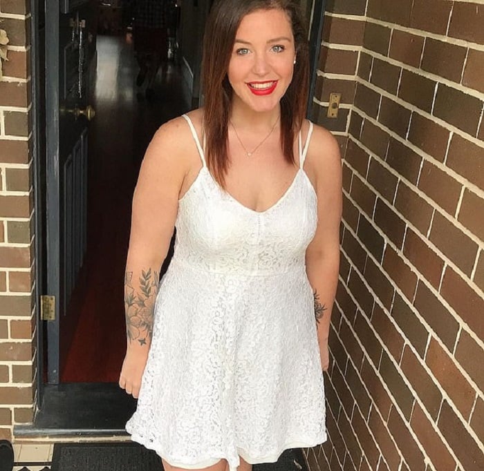 Alida posando para una foto después de haber adelgazado, usnado un vestido blanco
