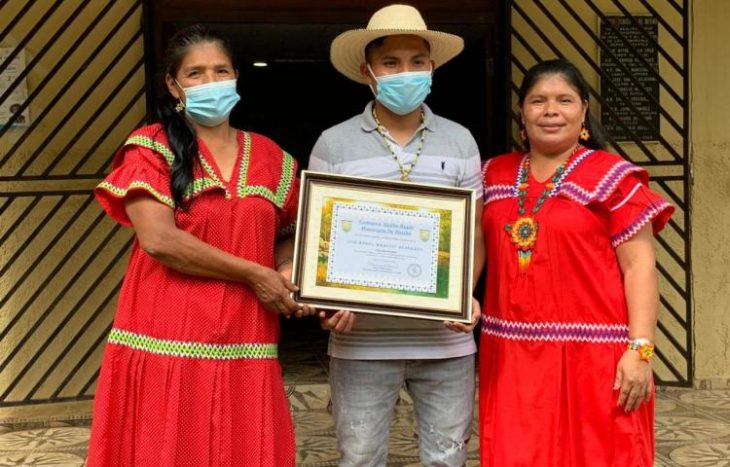 Luis Ángel mostrando su diploma de egresado con su familia en la comarca de Panamá