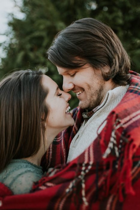 pareja sonriendo y abrazándose a punto de besarse