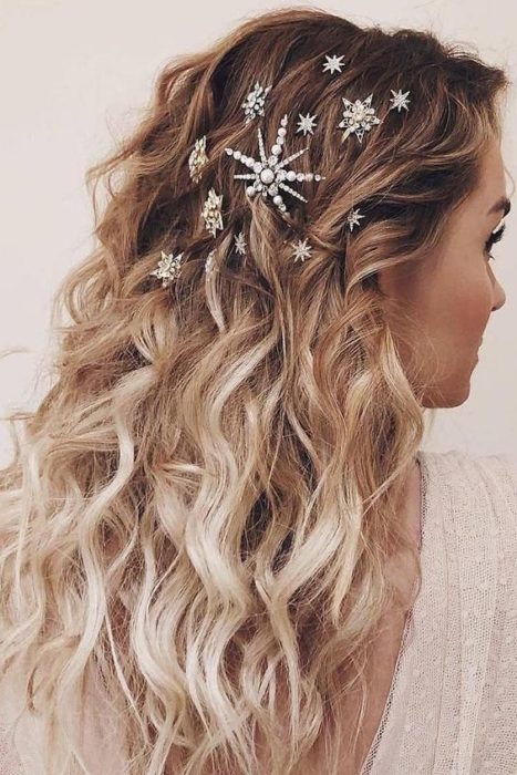 Chica rubia de espaldas con cabello suelto y broches de estrellas