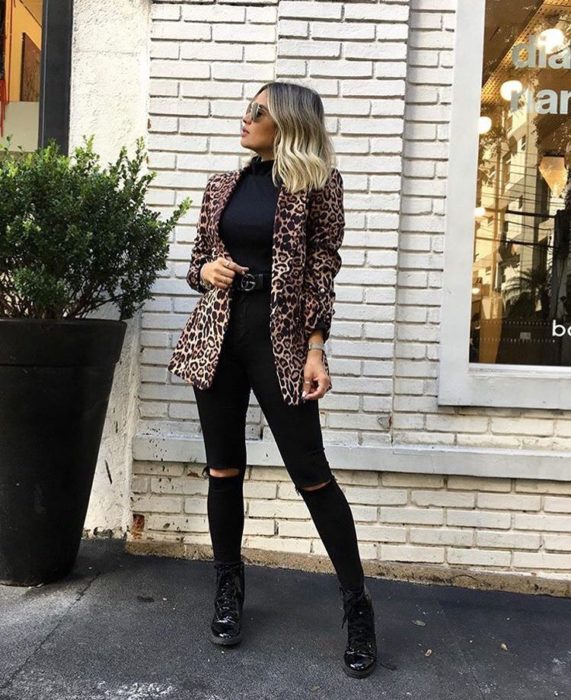 Chica usando blazer de estampado animal print, y blusa, zapatos y botines color negros