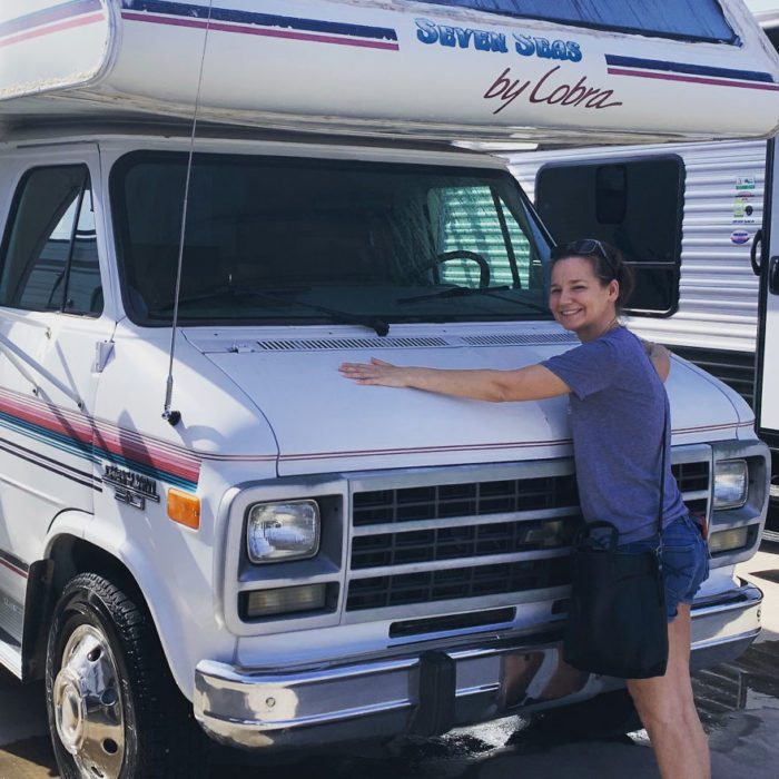 chica abrazando una camioneta van blanca