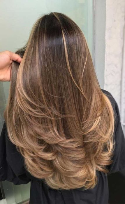 Mujer de cabello castaño claro con corte en capas