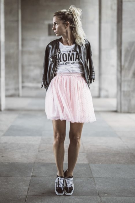 Chica usando falda de tul color rosa y playera blanca con una chamarra de cuero negra