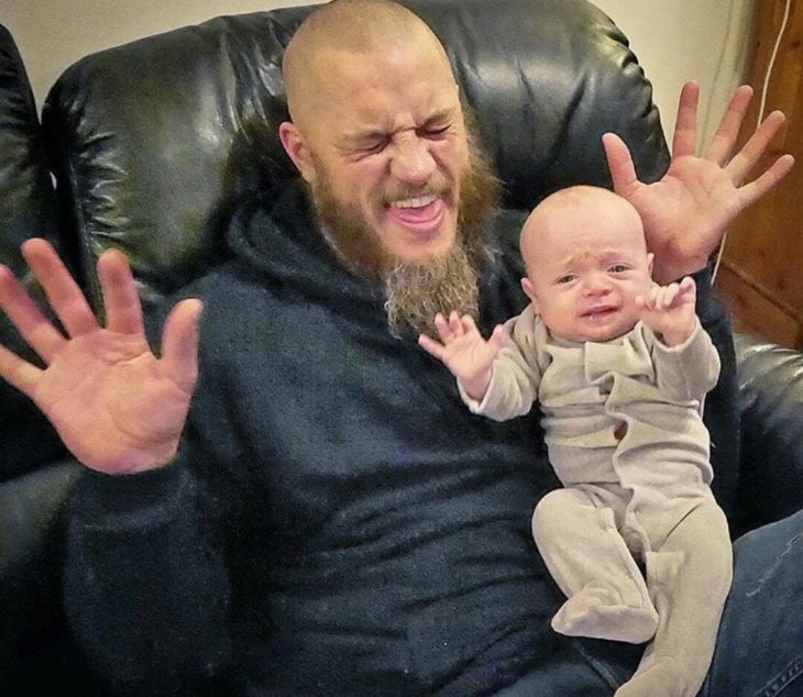 Travis Fimmel con un bebé haciendo caras graciosas