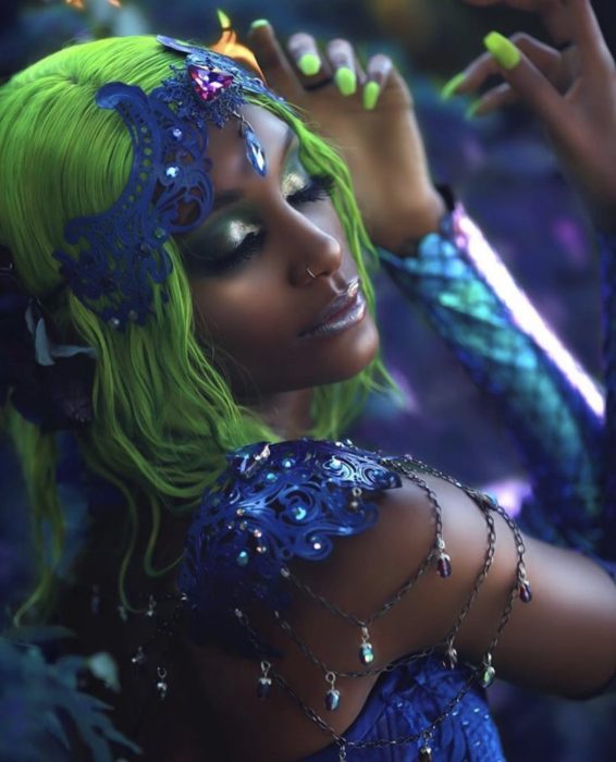 Mujer negra posando con peluca verde y vestuario de sirena