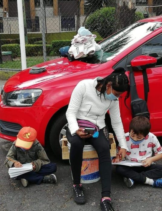 Mujer franelera hace tarea con sus hijos en la calle