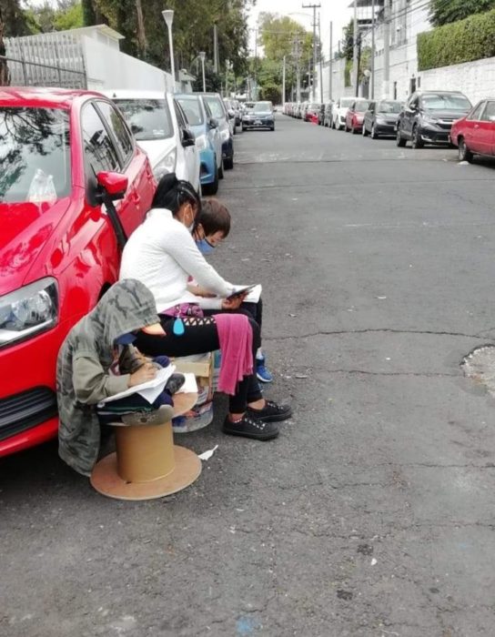 Mujer franelera hace tarea con sus hijos en la calle